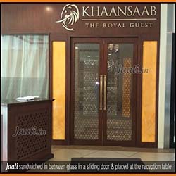 Mashrabiya styled Jaali sandwiched in between the glass of the entrance door & also placed on  the face of the reception table copy